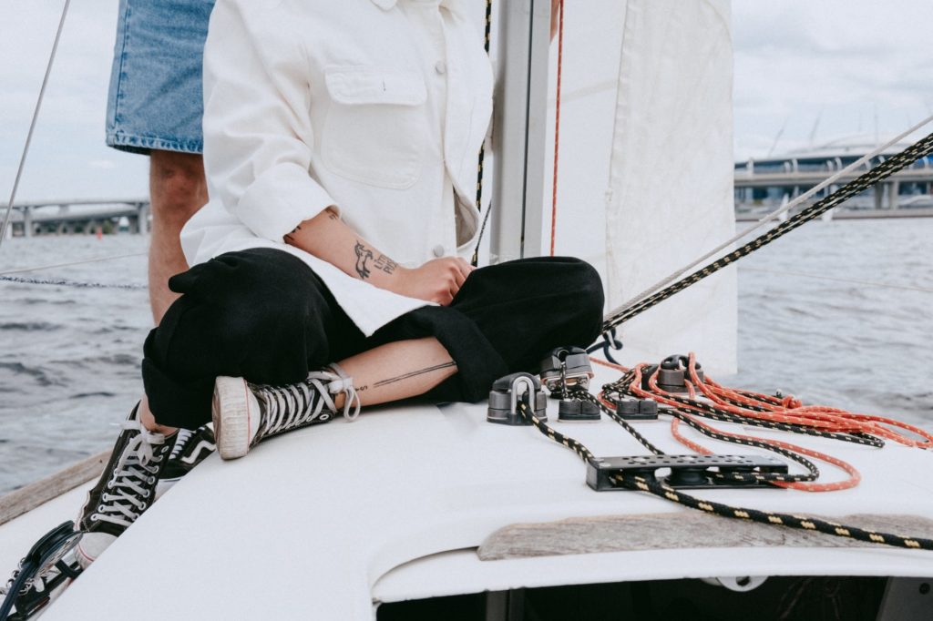 man in white button up shirt sitting on white boat